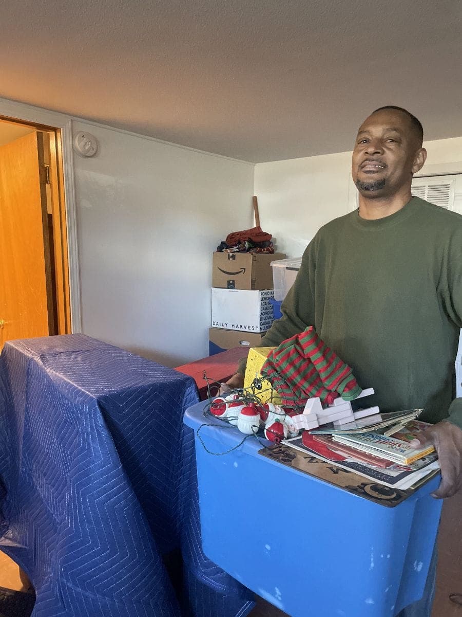 picture of a mover moving things from a living room onto a moving truck