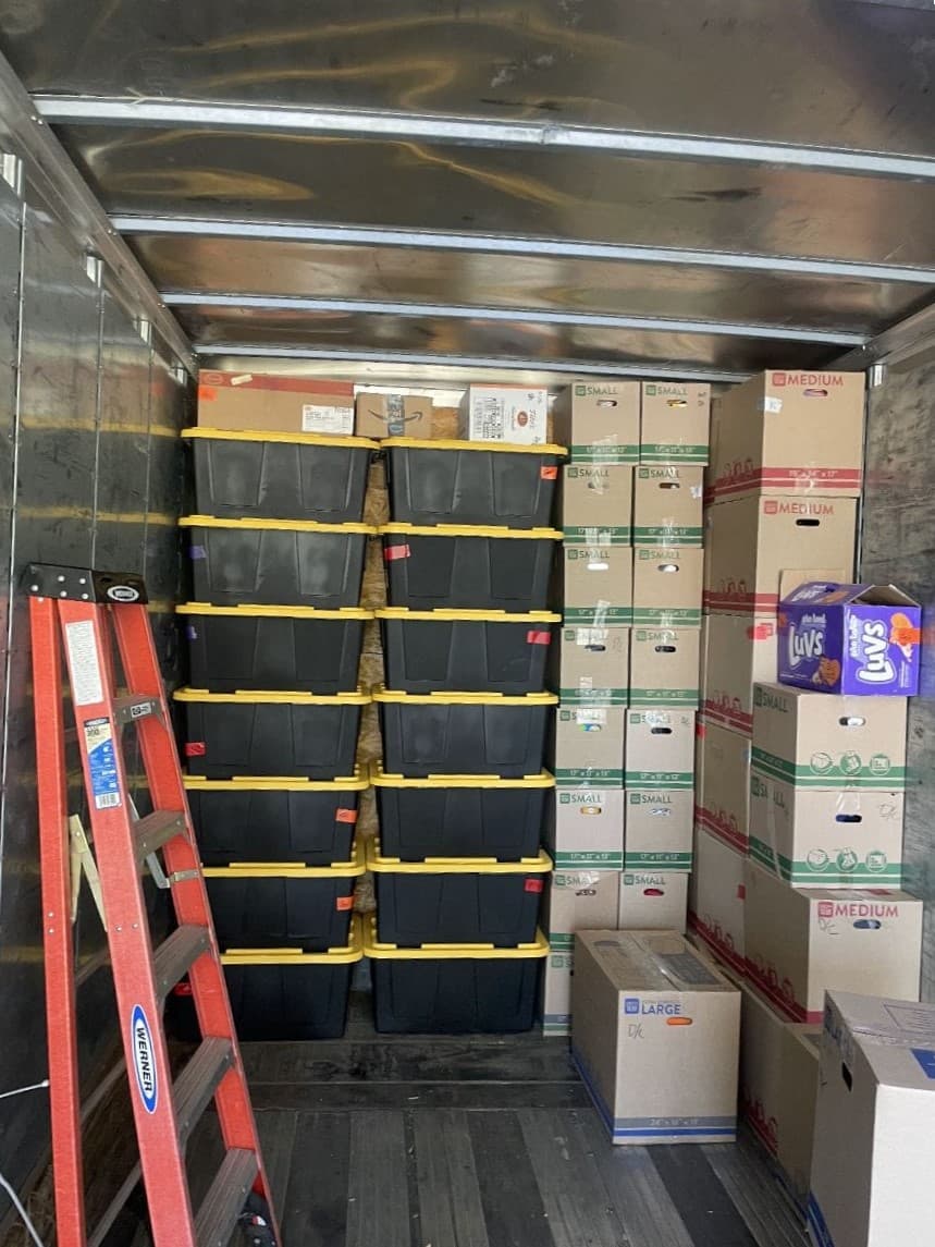 picture of a bunch of boxes stacked up in the back of a box truck ready to be moved to their new location 